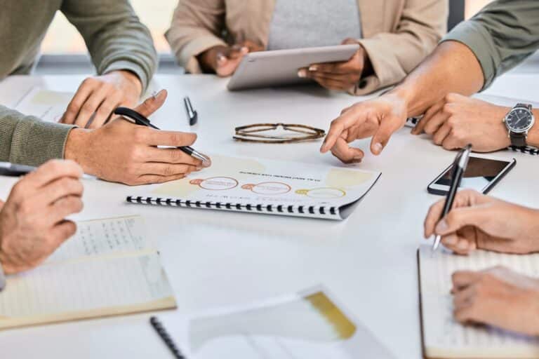 A table with a group of business owners taking notes and reviewing documents
