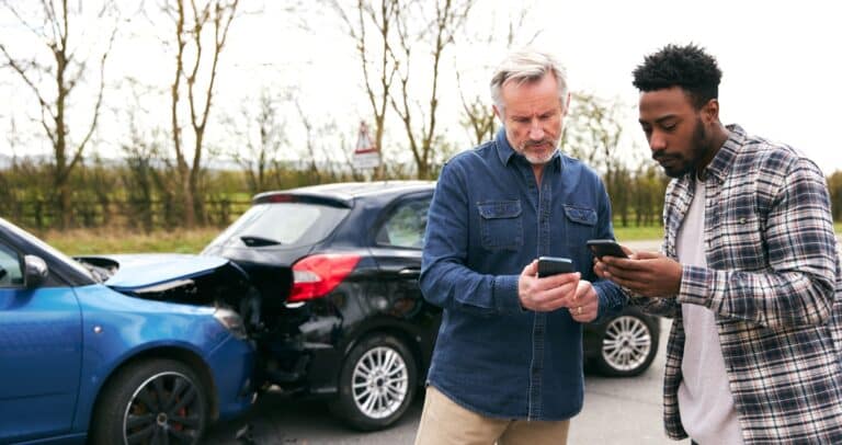 Two people exchanging information at the scene of an accident