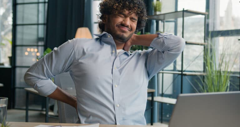 A man holding his neck and back showing he is in pain